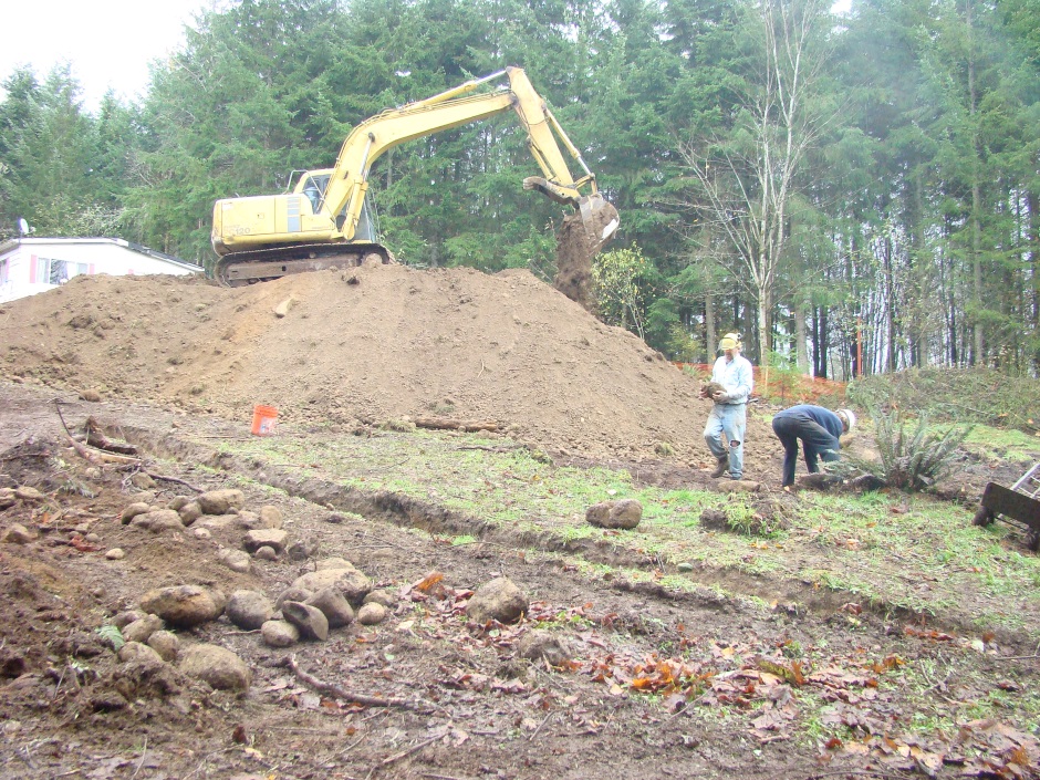 Excavator on mound getting rocks