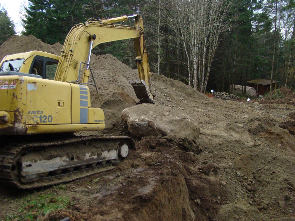 Excavator moving rock