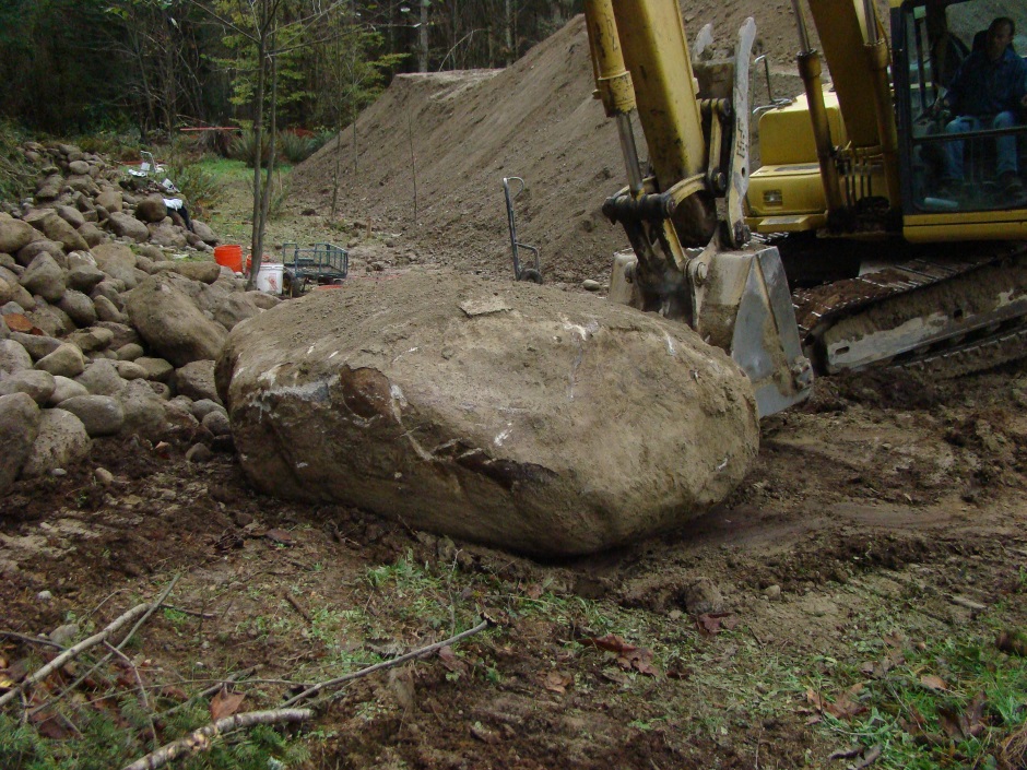 Excavator moving rock